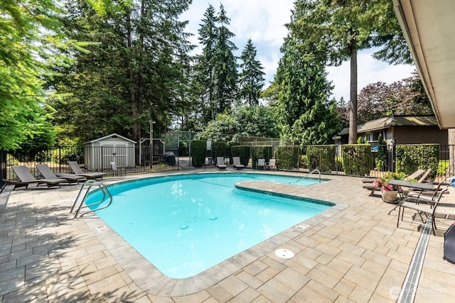 4601 SW 320th St Unit K4, Federal Way, WA 98023 - community pool featuring a patio area, view of wooded area, and an outbuilding