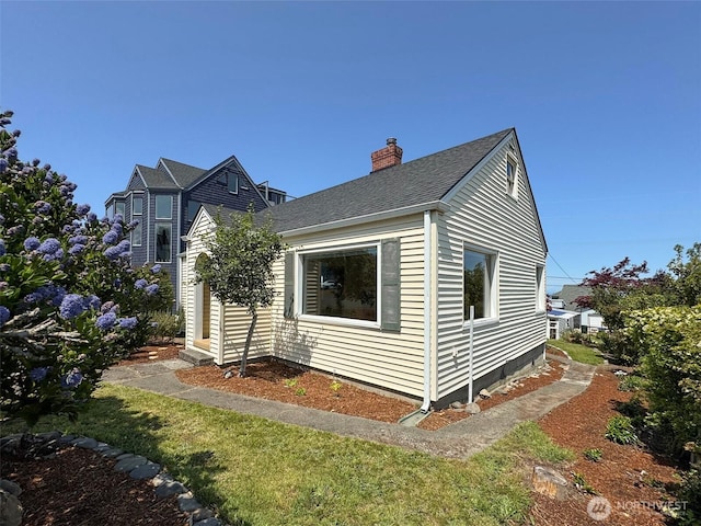 1025 W 6th St, Port Angeles, WA 98363 - view of home's exterior with a chimney and a shingled roof