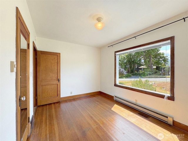 1025 W 6th St, Port Angeles, WA 98363 - empty room with a baseboard radiator, wood finished floors, and baseboards