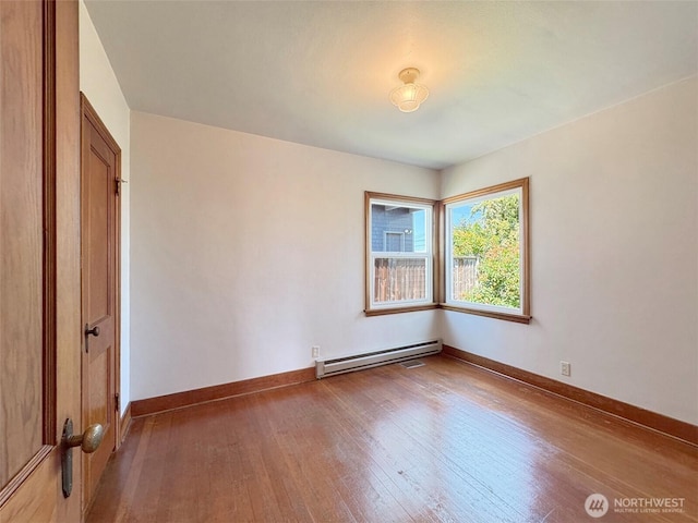 1025 W 6th St, Port Angeles, WA 98363 - spare room featuring baseboard heating, hardwood / wood-style floors, and baseboards