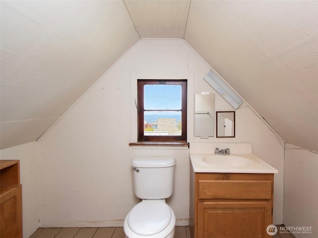 1025 W 6th St, Port Angeles, WA 98363 - half bathroom with vanity, vaulted ceiling, toilet, and tile patterned floors