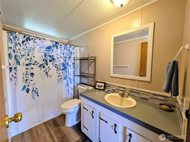201 Hemlock St, Orcas Island, WA 98245 - bathroom featuring vanity, toilet, a textured ceiling, wood finished floors, and ornamental molding