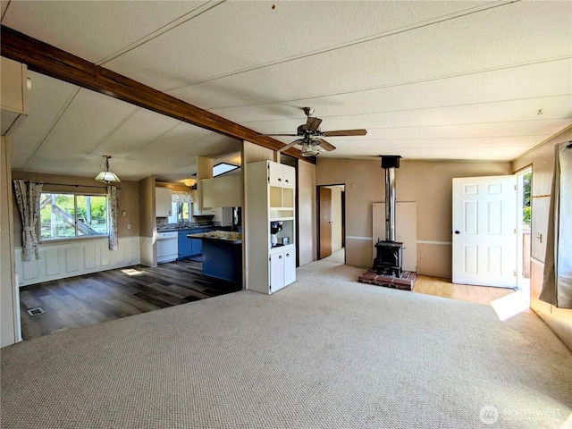 201 Hemlock St, Orcas Island, WA 98245 - unfurnished living room with a wood stove, ceiling fan, dark carpet, and dark wood finished floors