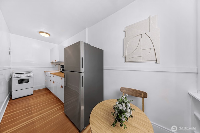 4725 15th Ave NE Unit 37, Seattle, WA 98105 - kitchen featuring freestanding refrigerator, white range with electric stovetop, a sink, light wood-style flooring, and white cabinets