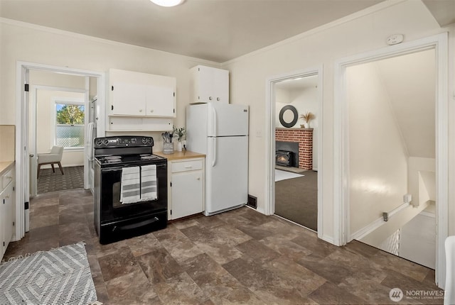 5011 5th Ave NE, Seattle, WA 98105 - kitchen with black range with electric cooktop, freestanding refrigerator, white cabinets, light countertops, and ornamental molding