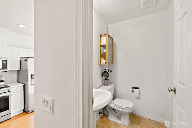 11864 NE 162nd Ln Unit 11-2, Bothell, WA 98011 - bathroom featuring toilet, baseboards, and tile patterned floors