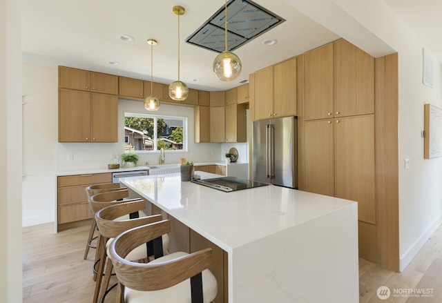 3304 37th Ave S, Seattle, WA 98144 - kitchen featuring high quality fridge, light wood-style floors, cooktop, a kitchen island, and light countertops
