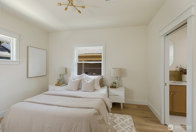 3304 37th Ave S, Seattle, WA 98144 - bedroom featuring light wood-style flooring, baseboards, and a chandelier