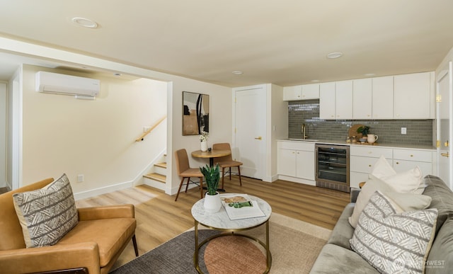 3304 37th Ave S, Seattle, WA 98144 - living room with beverage cooler, a wall mounted AC, light wood finished floors, bar with sink, and stairway