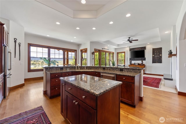 134 Borealis Ln, Manson, WA 98831 - kitchen featuring a raised ceiling, a kitchen island, appliances with stainless steel finishes, light wood-style floors, and baseboards