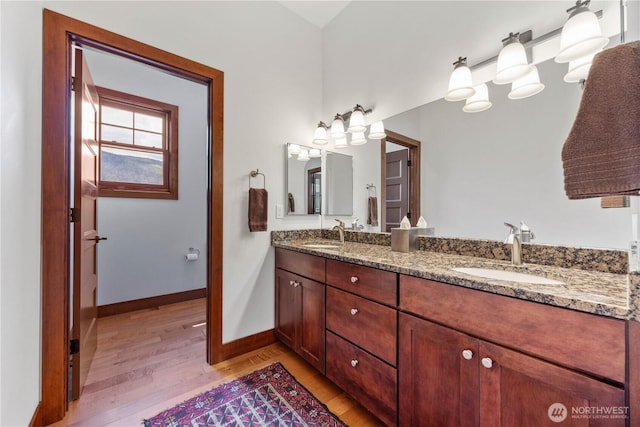 134 Borealis Ln, Manson, WA 98831 - bathroom featuring wood finished floors, double vanity, and baseboards