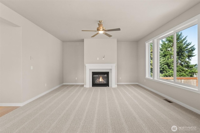 9645 7th Ave SE, Lacey, WA 98513 - unfurnished living room with a glass covered fireplace, ceiling fan, and light carpet