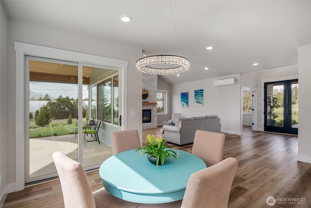 3848 Marine Way, Bellingham, WA 98225 - dining area with a wall mounted air conditioner, wood finished floors, french doors, vaulted ceiling, and baseboards