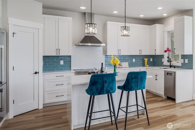 3848 Marine Way, Bellingham, WA 98225 - kitchen featuring dishwasher, wall chimney exhaust hood, a breakfast bar area, light countertops, and recessed lighting