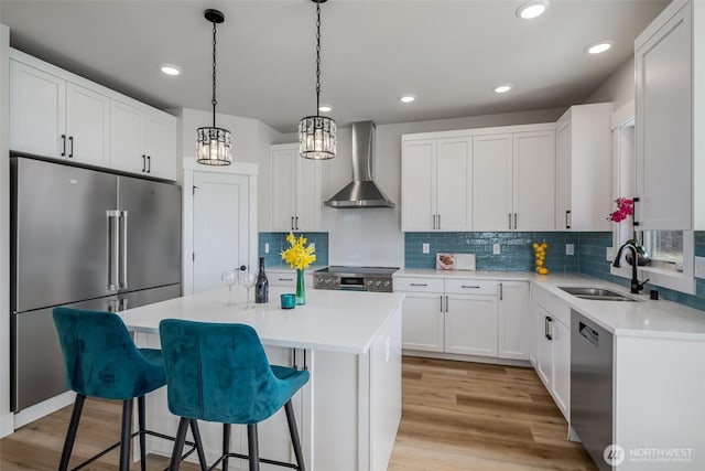 3848 Marine Way, Bellingham, WA 98225 - kitchen featuring appliances with stainless steel finishes, wall chimney range hood, a sink, a center island, and a breakfast bar area