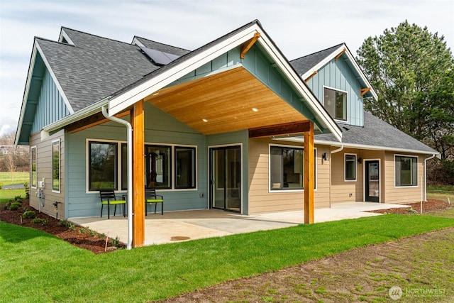3848 Marine Way, Bellingham, WA 98225 - back of property with board and batten siding, a patio area, a yard, and a shingled roof