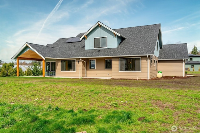 3848 Marine Way, Bellingham, WA 98225 - back of house featuring roof mounted solar panels, a yard, a shingled roof, a patio, and board and batten siding