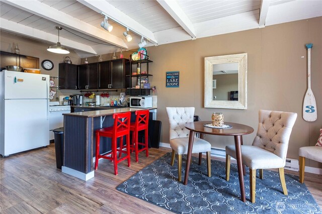 135 Furey Ave, Manson, WA 98831 - dining space with wood finished floors, beamed ceiling, a baseboard heating unit, and baseboards