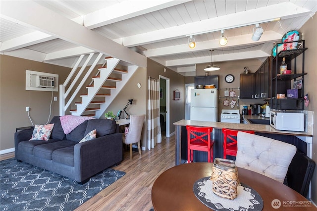 135 Furey Ave, Manson, WA 98831 - living room featuring light wood-style floors, an AC wall unit, baseboards, stairs, and wood ceiling with exposed beams