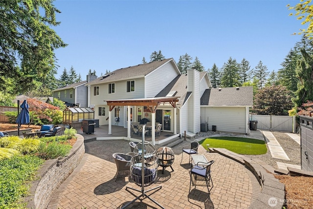 1228 Tabitha Ct NW, Olympia, WA 98502 - rear view of house featuring a fire pit, a wooden deck, a patio area, and a gate