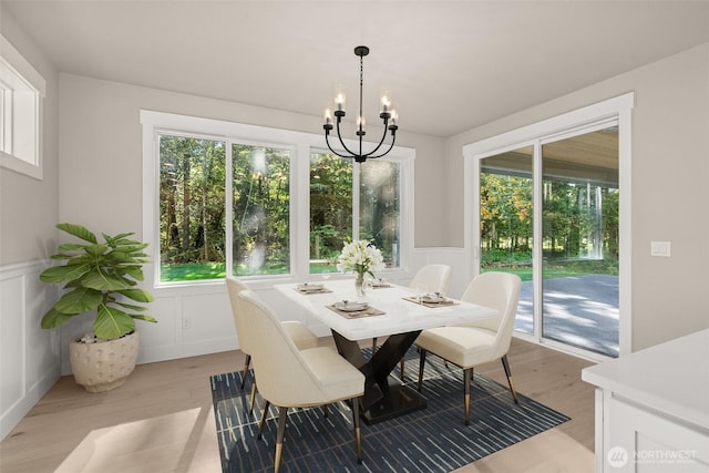 2446 64th Ave NW, Olympia, WA 98502 - dining space featuring a decorative wall, light wood finished floors, plenty of natural light, a wainscoted wall, and a chandelier