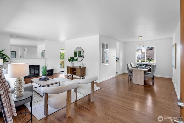 4619 SW Genesee St, Seattle, WA 98116 - living area featuring healthy amount of natural light, wood finished floors, a fireplace, and baseboards