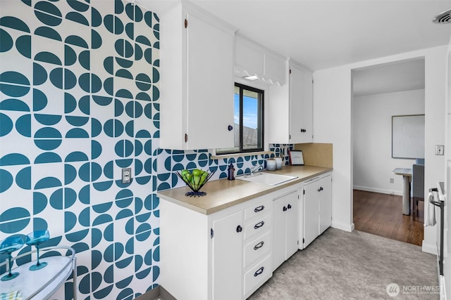4619 SW Genesee St, Seattle, WA 98116 - kitchen featuring light countertops, a sink, white cabinets, and backsplash