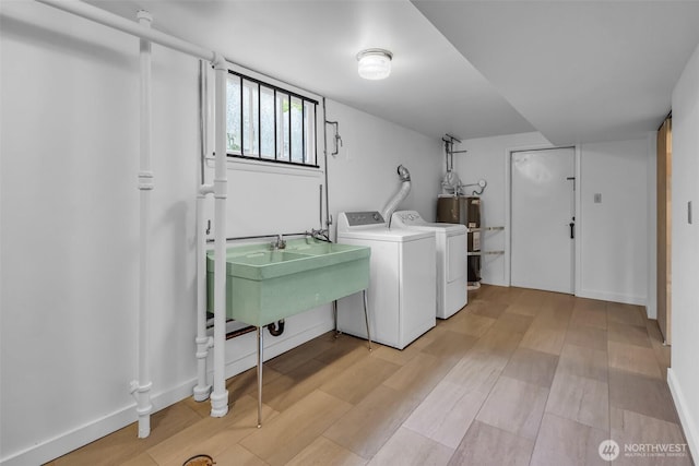 4619 SW Genesee St, Seattle, WA 98116 - laundry room featuring washing machine and clothes dryer, light wood-style floors, water heater, and a sink