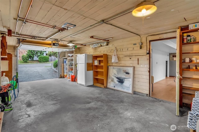 4619 SW Genesee St, Seattle, WA 98116 - garage with freestanding refrigerator, a garage door opener, and wooden walls