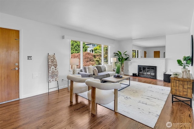 4619 SW Genesee St, Seattle, WA 98116 - living area featuring a fireplace, wood finished floors, and baseboards
