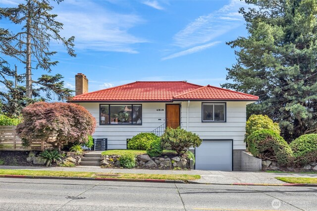 4619 SW Genesee St, Seattle, WA 98116 - view of front of home with a tile roof, an attached garage, a chimney, and driveway