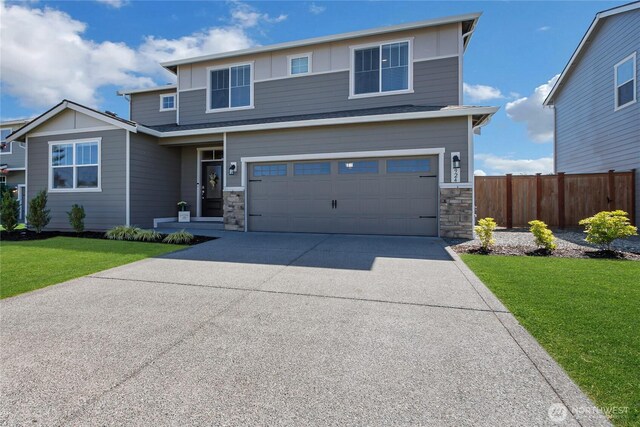 924 Livernash St, Buckley, WA 98321 - view of front facade featuring an attached garage, stone siding, driveway, and board and batten siding