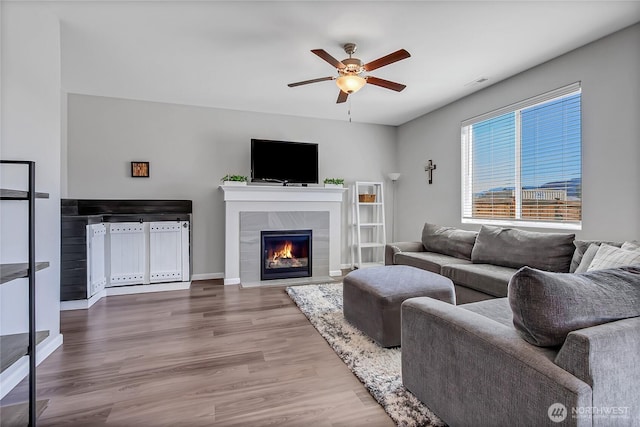 924 Livernash St, Buckley, WA 98321 - living room with ceiling fan, wood finished floors, a tile fireplace, and baseboards