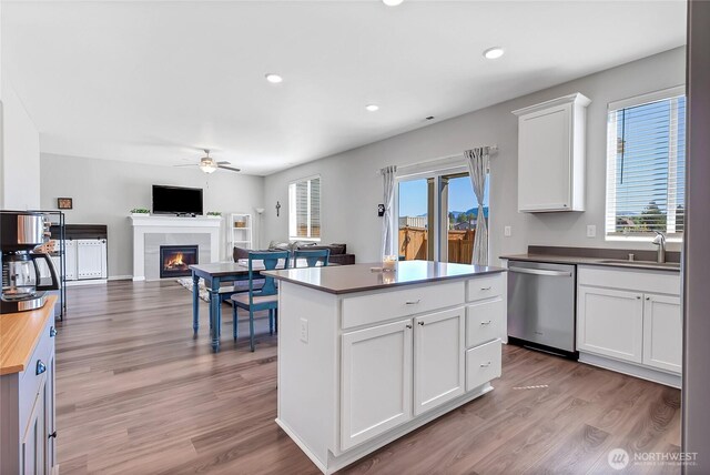 924 Livernash St, Buckley, WA 98321 - kitchen with dishwasher, a ceiling fan, a tile fireplace, butcher block countertops, and light wood-style floors