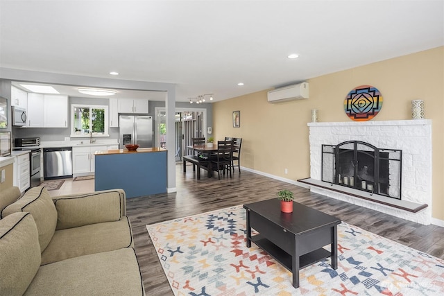18312 73rd Ave W, Edmonds, WA 98026 - living area with a wall mounted AC, wood finished floors, baseboards, a fireplace, and recessed lighting