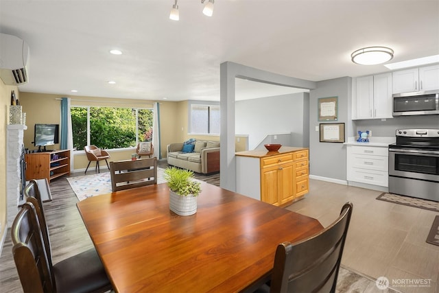 18312 73rd Ave W, Edmonds, WA 98026 - dining space with a wall mounted air conditioner, baseboards, recessed lighting, and light wood-type flooring