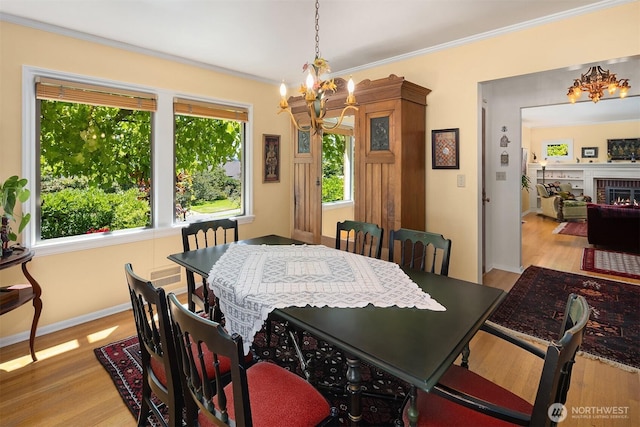 6045 Seward Park Ave S, Seattle, WA 98118 - dining room featuring a chandelier, wood finished floors, crown molding, and a brick fireplace