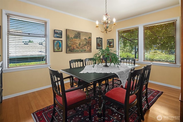 6045 Seward Park Ave S, Seattle, WA 98118 - dining area featuring a chandelier, wood finished floors, ornamental molding, and healthy amount of natural light
