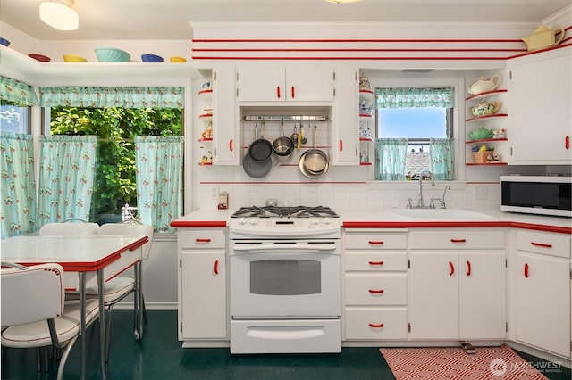 6045 Seward Park Ave S, Seattle, WA 98118 - kitchen with gas range gas stove, open shelves, white cabinets, light countertops, and tasteful backsplash