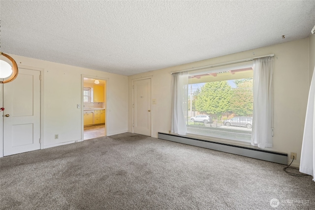 8608 16th Ave SW, Seattle, WA 98106 - unfurnished bedroom with a baseboard radiator, a textured ceiling, carpet flooring, and connected bathroom