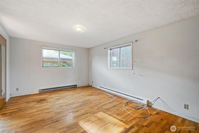 8608 16th Ave SW, Seattle, WA 98106 - unfurnished room featuring baseboard heating, light wood-style flooring, plenty of natural light, and a textured ceiling