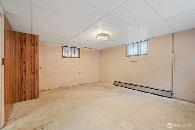 8608 16th Ave SW, Seattle, WA 98106 - basement featuring baseboard heating, a paneled ceiling, and wooden walls