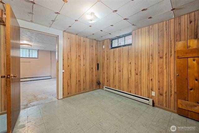 8608 16th Ave SW, Seattle, WA 98106 - basement featuring a baseboard heating unit, wood walls, tile patterned floors, and a paneled ceiling