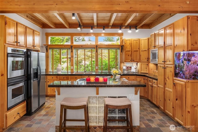 16375 NE 44th Ct, Redmond, WA 98052 - kitchen with appliances with stainless steel finishes, rail lighting, a breakfast bar, wooden ceiling with exposed beams, and a sink