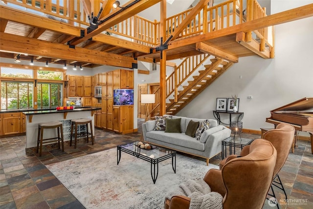 16375 NE 44th Ct, Redmond, WA 98052 - living room with stone tile floors, stairs, baseboards, a chandelier, and a high ceiling