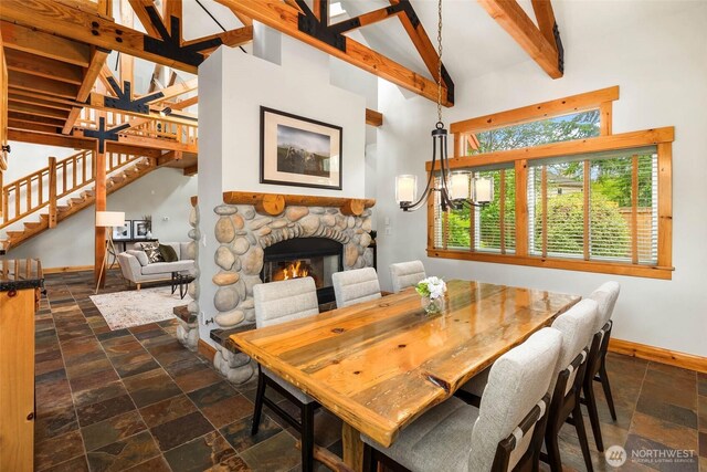16375 NE 44th Ct, Redmond, WA 98052 - dining space with stairway, baseboards, stone tile floors, a fireplace, and beamed ceiling