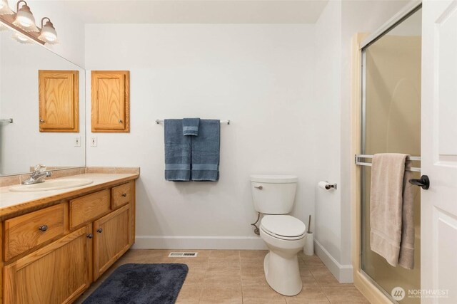 16375 NE 44th Ct, Redmond, WA 98052 - full bathroom with vanity, a shower stall, toilet, tile patterned floors, and baseboards