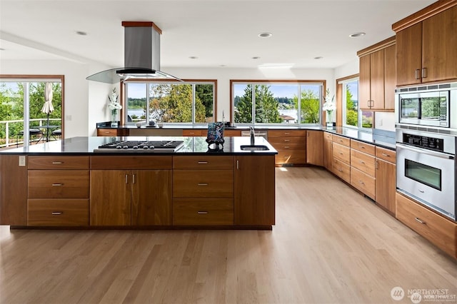 8533 NE Juanita Dr, Kirkland, WA 98034 - kitchen with stainless steel appliances, dark countertops, light wood-style flooring, island exhaust hood, and recessed lighting