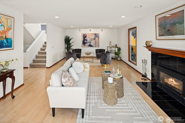 8533 NE Juanita Dr, Kirkland, WA 98034 - living room with light wood-style flooring, stairs, a tiled fireplace, recessed lighting, and baseboards