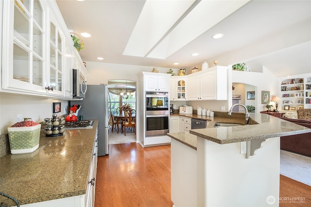418 158th Pl NW, Arlington, WA 98223 - kitchen with a sink, appliances with stainless steel finishes, a peninsula, a kitchen breakfast bar, and light wood-type flooring